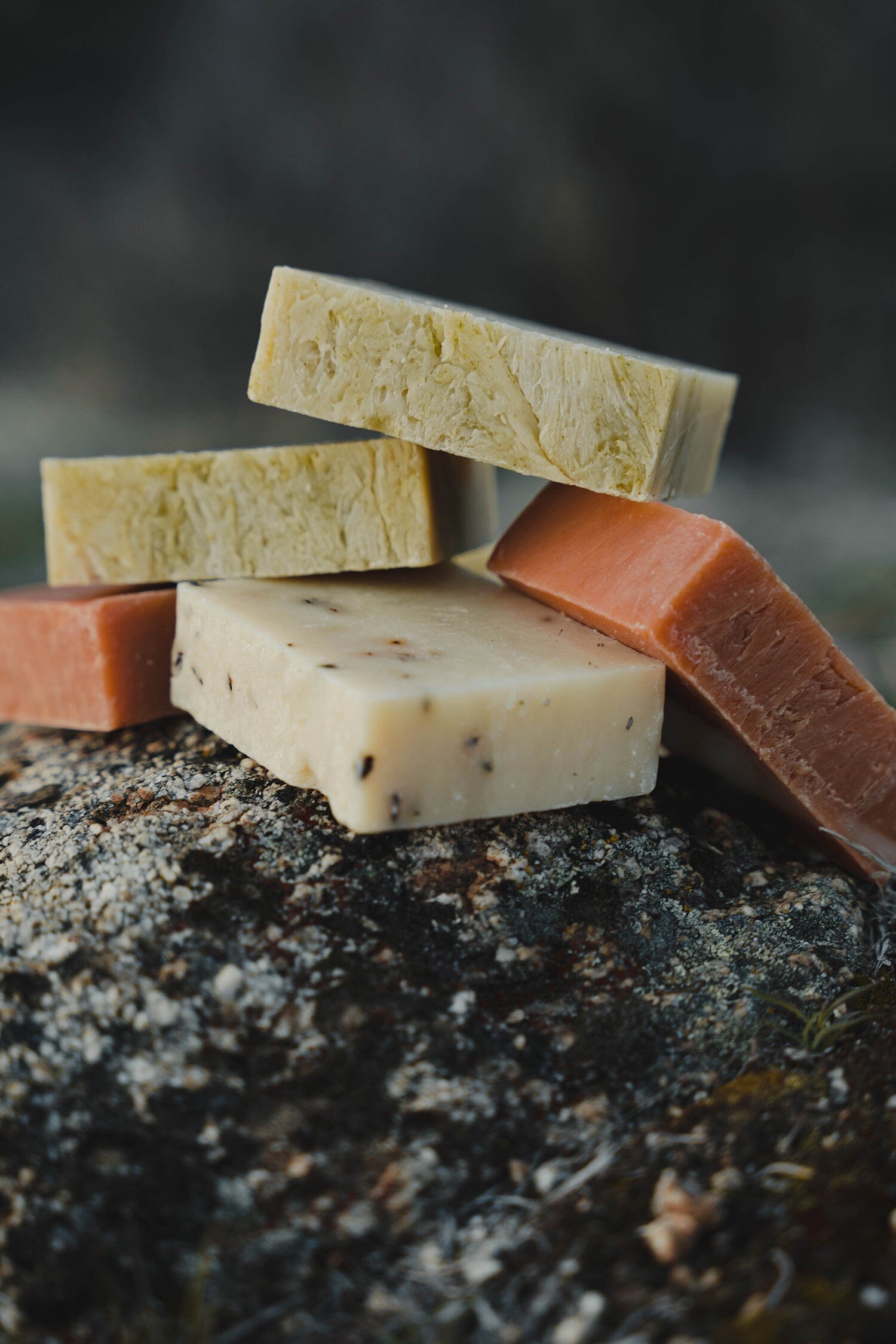 Three all-natural, organic bar soap formulas from Iron Lion Soap stacked on a rocky mountain.